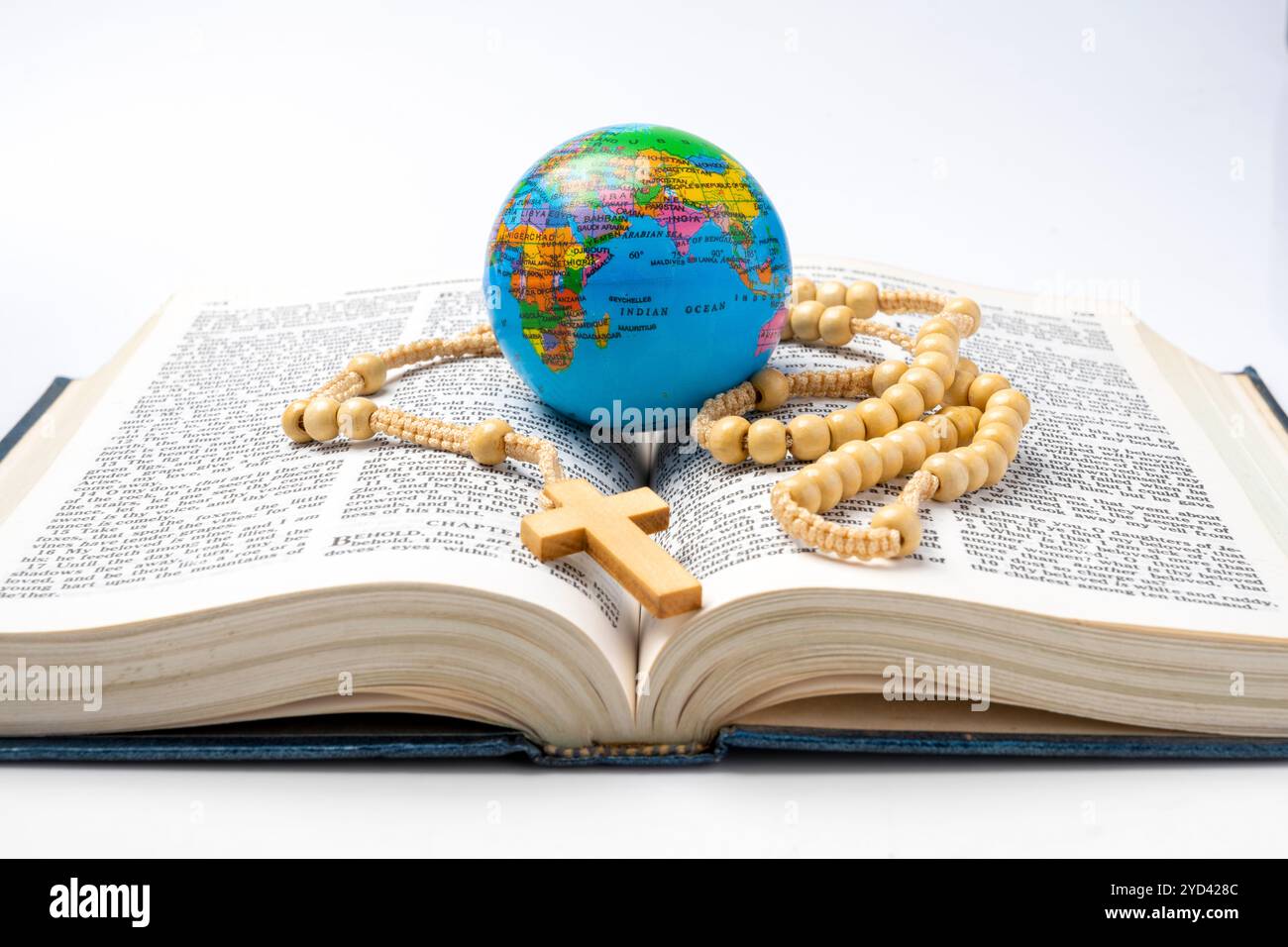 Livre ouvert de la Sainte Bible avec des perles de chapelet et globe. Il est posé sur fond blanc. Symbole de foi et de culte en Dieu. Religieux chrétien servi Banque D'Images