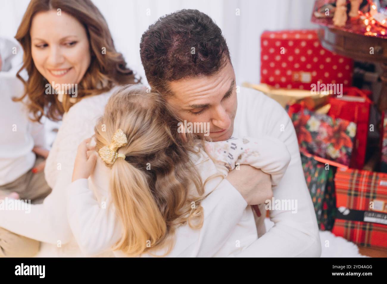 Papa serre sa petite fille dans ses bras au sapin de Noël Banque D'Images