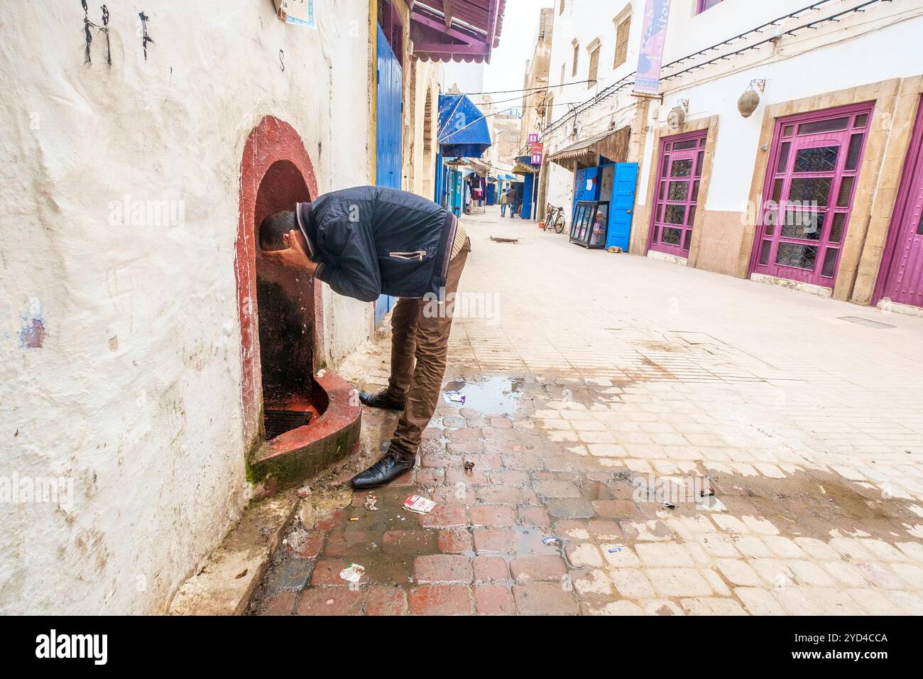 Un marocain utilisant une fontaine d'eau publique à Essaouira, Maroc Banque D'Images