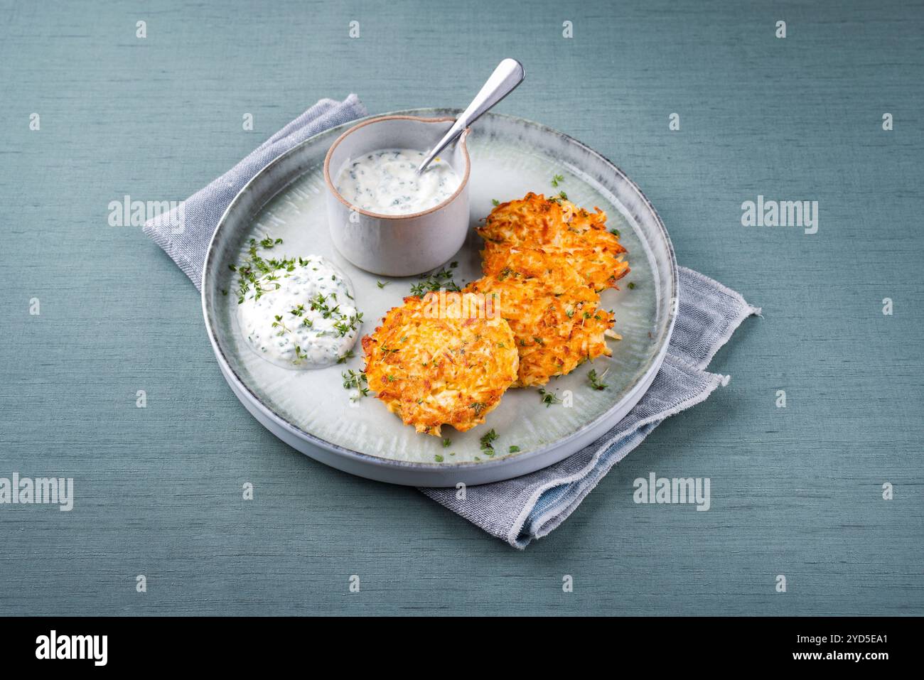 Crêpes de pommes de terre au panais traditionnelles avec ciboulette et sauce au fromage blanc servies en gros plan sur une assiette Nordic Design avec espace texte Banque D'Images