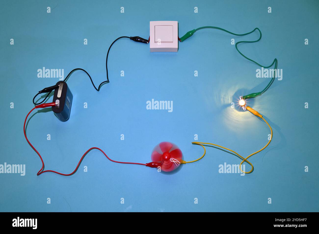 Circuit électrique éducatif basse tension composé d'une batterie, d'un interrupteur, d'un moteur entraînant un ventilateur et d'une ampoule. Banque D'Images
