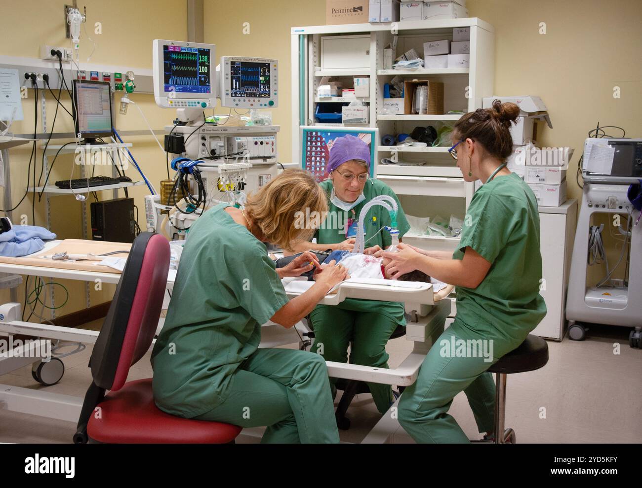 Une équipe de professionnels de la santé travaillant ensemble dans une pépinière d'hôpital ou une unité de soins intensifs néonatals (USIN). Banque D'Images