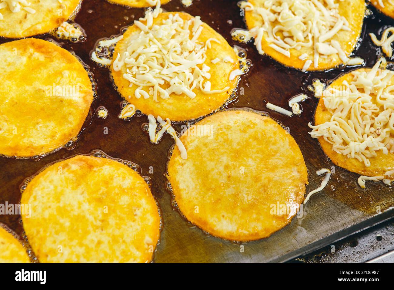 Faire frire des tortillas tacos avec du fromage sur la plaque chauffante dans la cuisine professionnelle dans le restaurant. Cuisine mexicaine, restauration rapide latino-américaine Banque D'Images