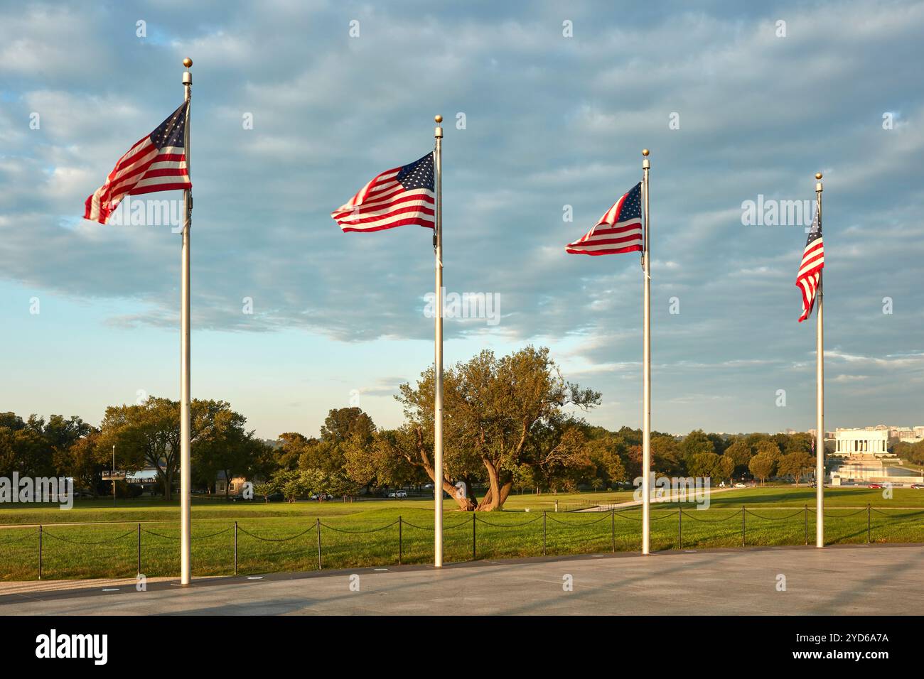 Une rangée de quatre drapeaux américains se dresse haut, agitant gracieusement dans la brise du soir sur fond d'un ciel partiellement nuageux. Les drapeaux sont positionnés en i. Banque D'Images