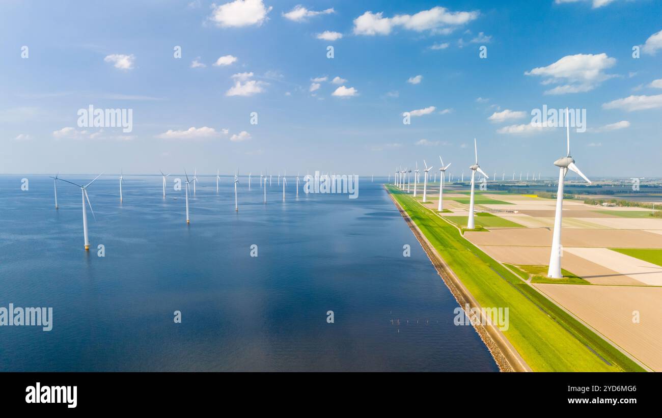 Une vue fascinante du ciel capture la danse gracieuse des éoliennes dans un vaste parc éolien océanique, situé aux pays-Bas Banque D'Images