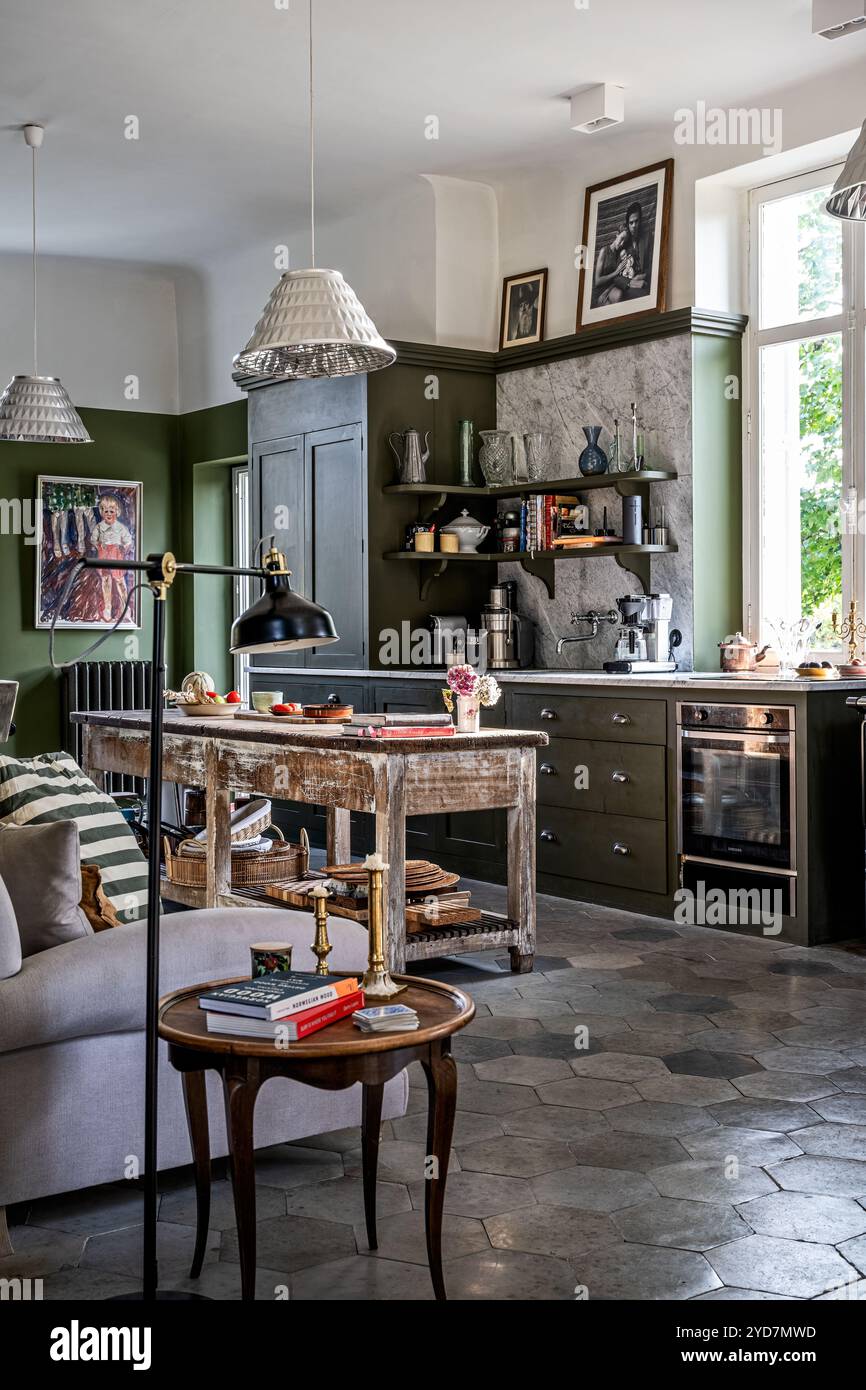 Table d'appoint et lampe de lecture dans une cuisine spacieuse vert olive, villa dans le sud de la France. Banque D'Images