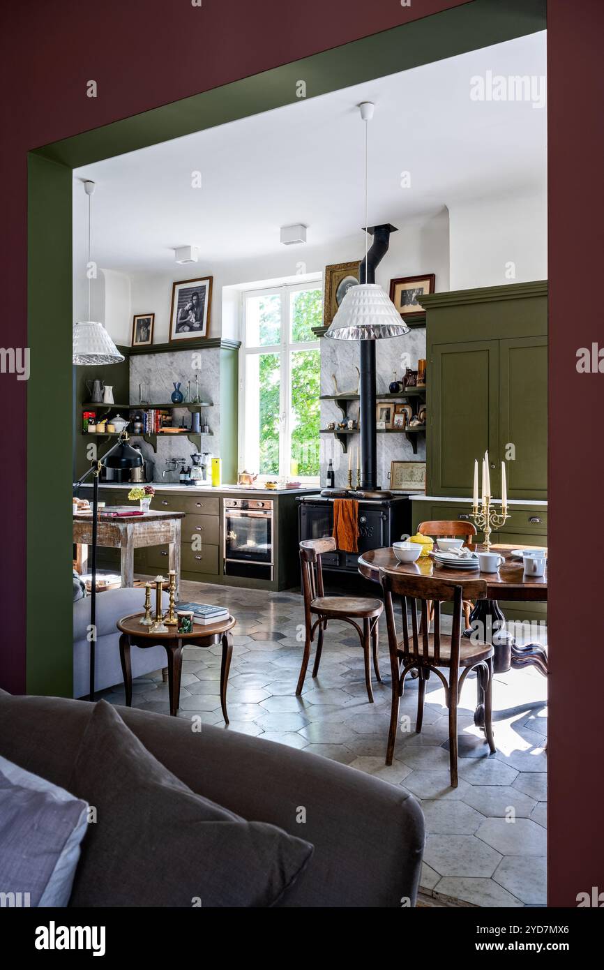 Vue à travers la cloison de la cuisine spacieuse vert olive dans la villa de luxe mise à jour dans le sud de la France. Banque D'Images