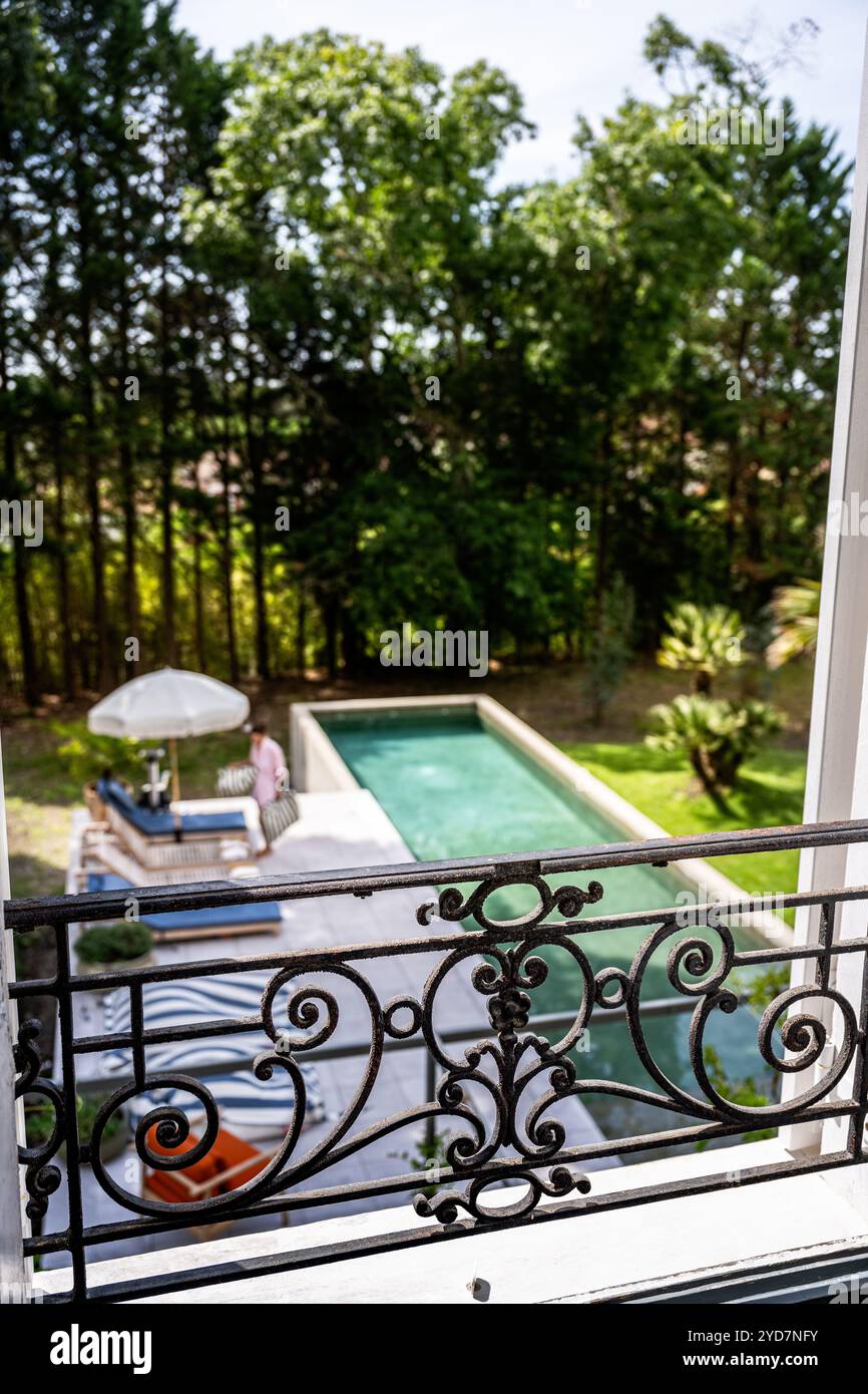 Vue depuis le balcon de la femme au bord de la piscine d'une villa de luxe dans le sud de la France. Banque D'Images