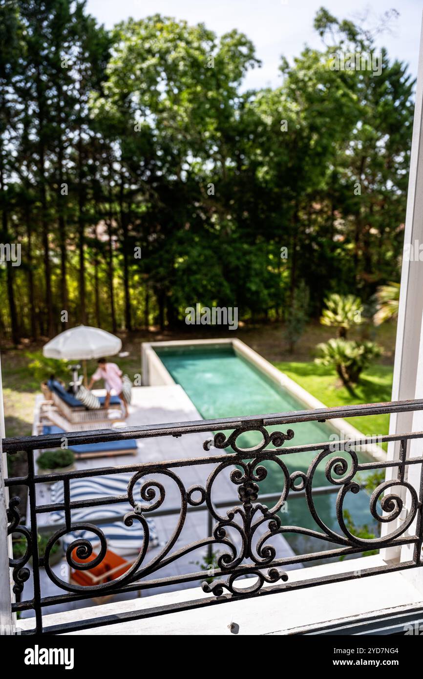 Vue depuis le balcon de la femme au bord de la piscine d'une villa de luxe dans le sud de la France. Banque D'Images