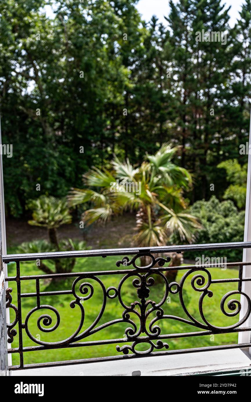 Détail balcon en fer forgé avec vue sur le jardin de la villa de luxe dans le sud de la France. Banque D'Images