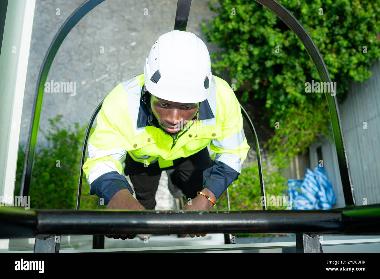 Le technicien monte une échelle sur le toit pour vérifier l'installation des panneaux solaires Banque D'Images