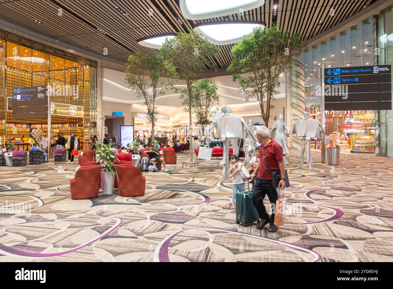 Aéroport de Singapour Changi terminal 4, passagers avec bagages, homme avec filles marchant Banque D'Images