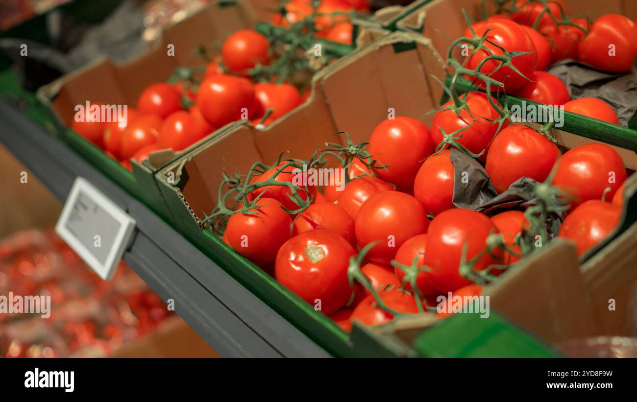 Tomates fraîches à l'épicerie. Légumes à vendre dans la caisse d'affichage de carton au supermarché Banque D'Images