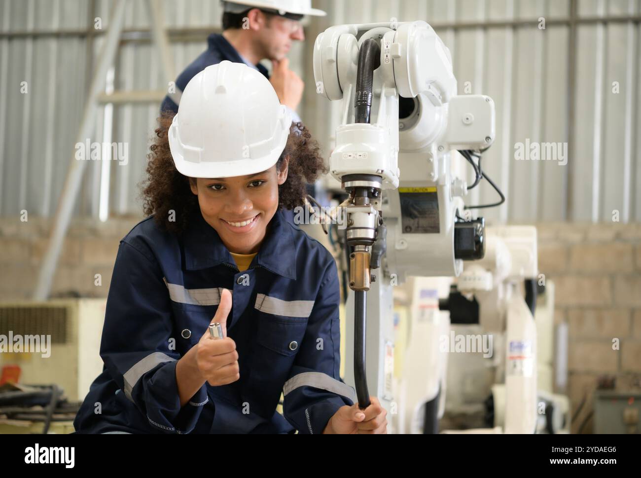 Les deux ingénieurs vérifient le fonctionnement des robots de soudage. Banque D'Images