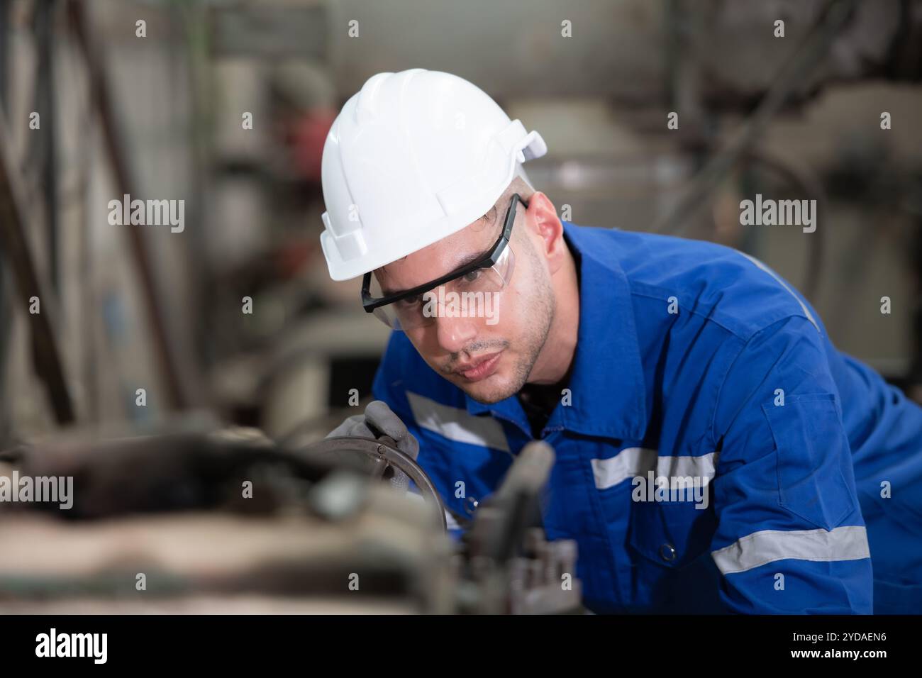 De jeunes ingénieurs expérimentés maintiennent et testent le fonctionnement des pièces de robot de soudage. Banque D'Images