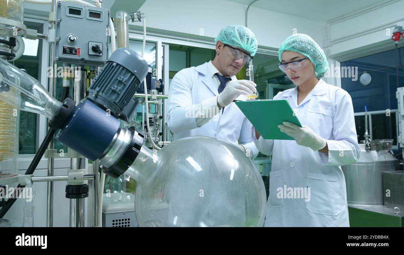 Des scientifiques et des assistants sont dans la salle des machines à extraire de l'huile et des graines de cannabis. Inspection de l'extracteur d'huile de cannabis avant St Banque D'Images