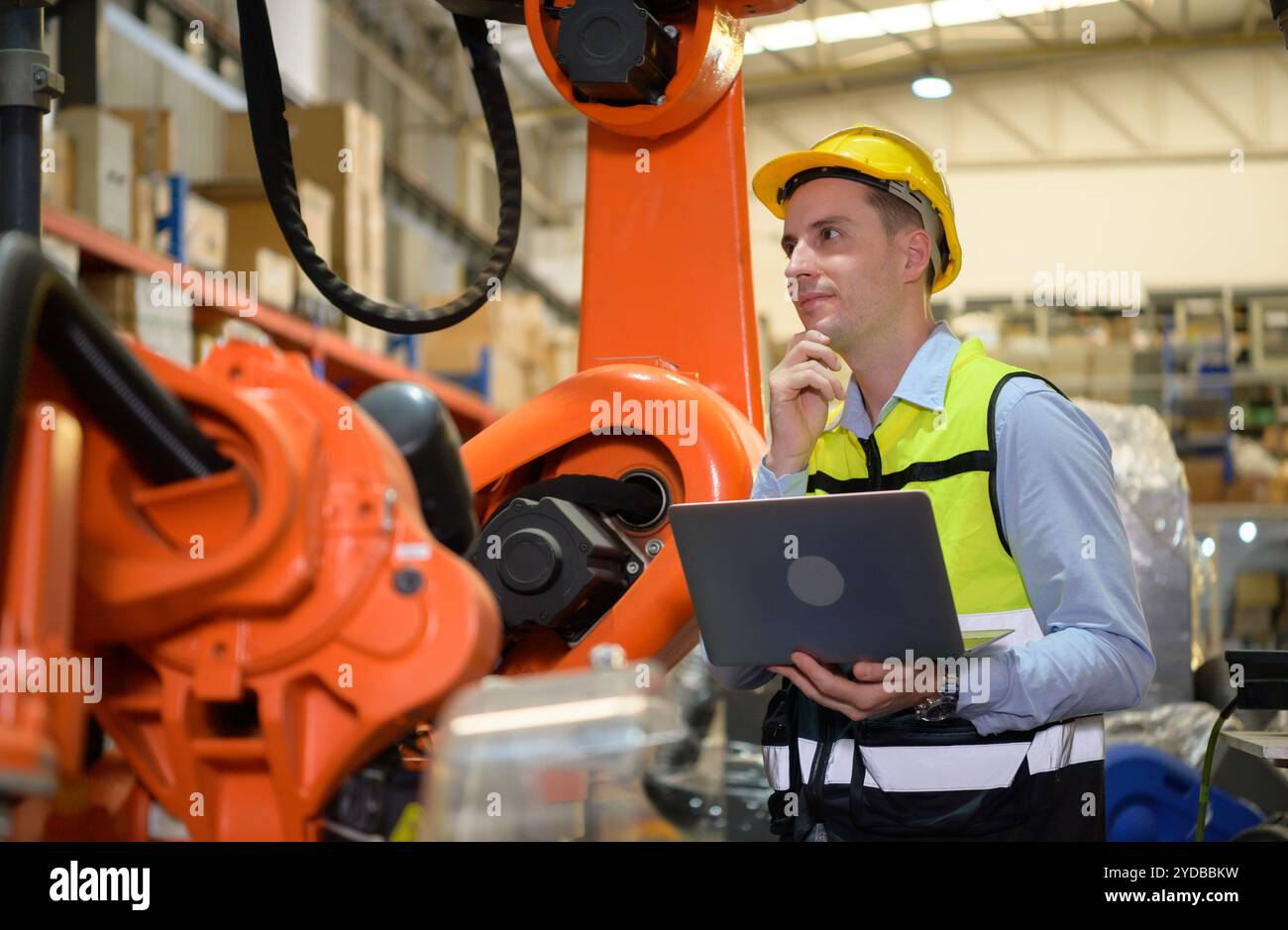 Un ingénieur vérifiant le fonctionnement d'un robot de soudage. Utilisé pour le contrôle de soudage de précision rapide et hautement sécurisé Banque D'Images