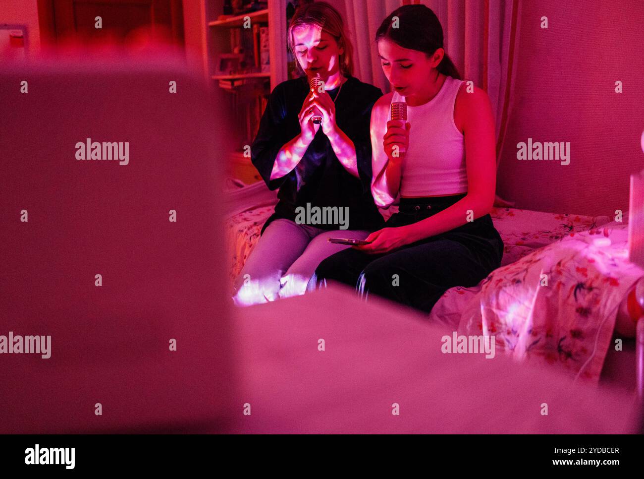 Deux adolescents mignons chantent des chansons de karaoké à la maison. De charmants amis dans des vêtements décontractés s'amusent ensemble. Jolis ados à un ho Banque D'Images