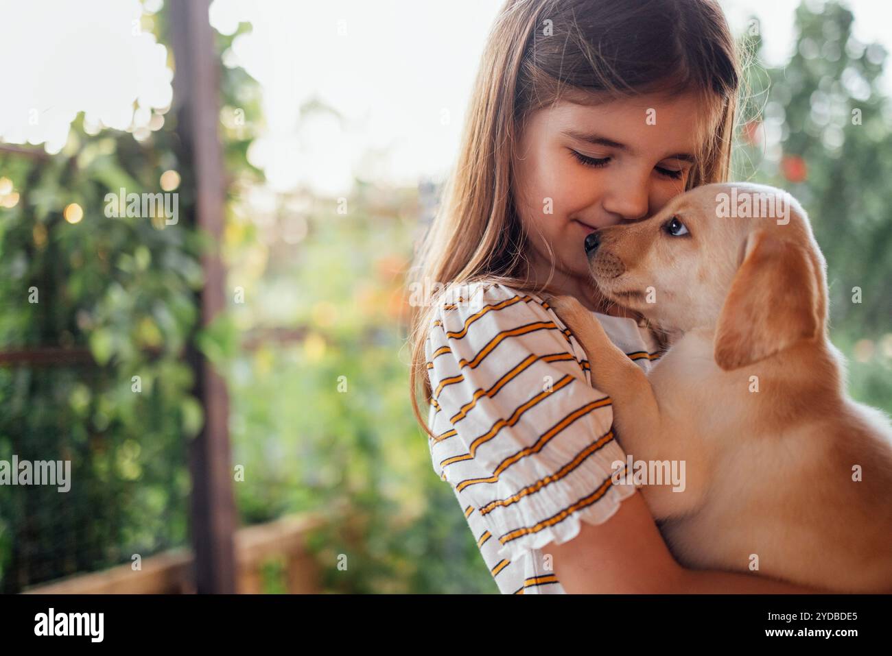 Portrait en gros plan d'une petite fille serrant un chiot dans ses bras. Un petit enfant mignon joue avec un chien. Un enfant doux est heureux avec son animal de compagnie. Un joli GI préscolaire Banque D'Images