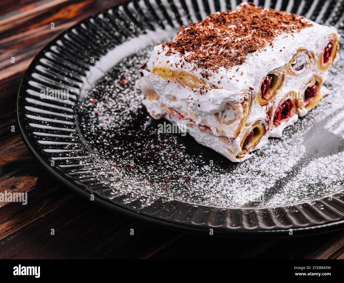 Trancher le gâteau forestier sur l'assiette noire Banque D'Images