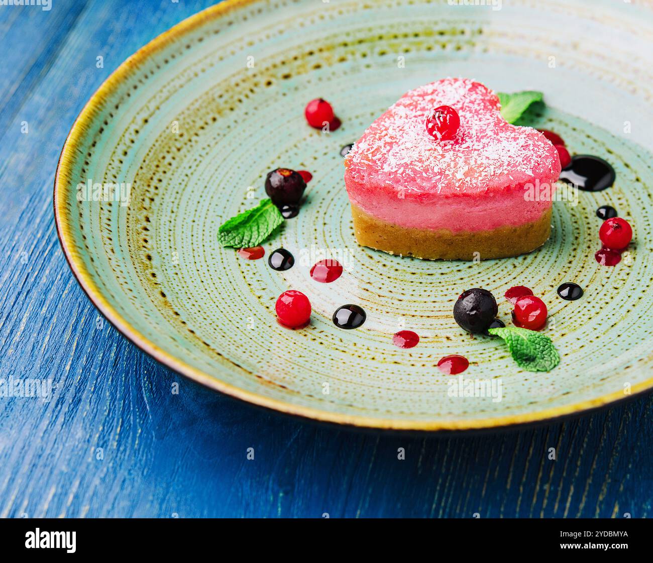 Gâteau rouge végétalien cru en forme de coeur avec framboises Banque D'Images