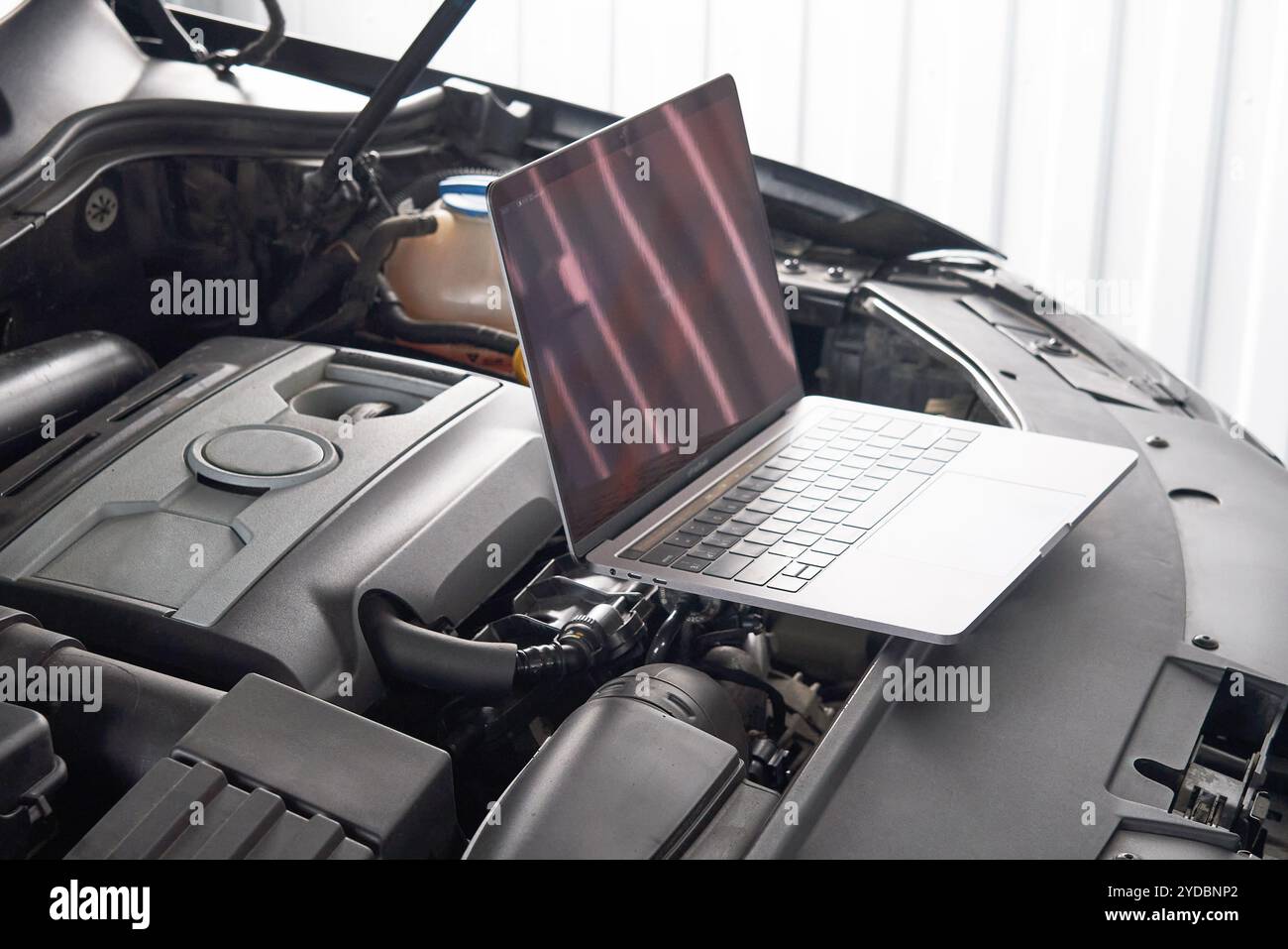 Ordinateur portable sur une voiture dans un atelier de réparation automobile, automobile mécanique réparateur concept Banque D'Images Ordinateur portable sur une voiture dans un atelier de réparation automobile, automobile mécanique réparateur concept Banque D'Images