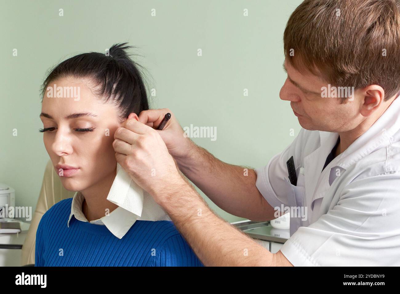 Médecin attentif faisant l'examen d'oreille de la jolie femme Banque D'Images