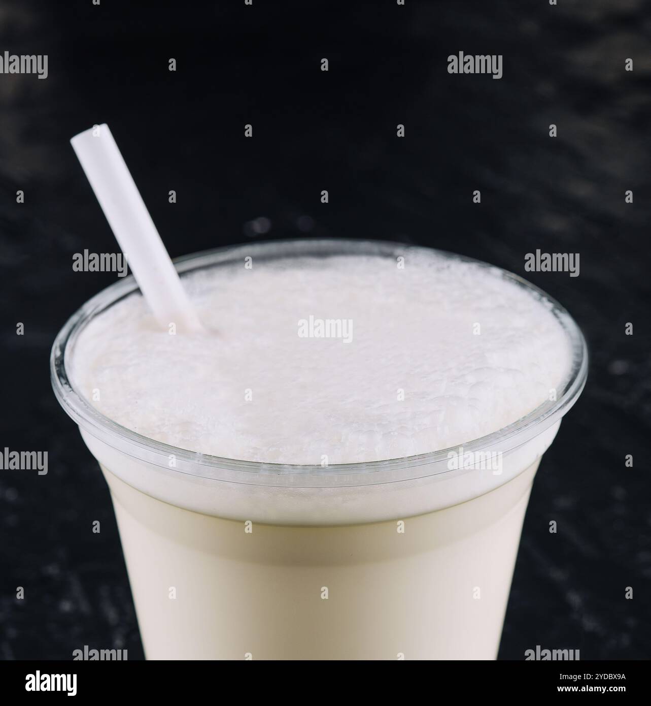 Milkshake dans une tasse en plastique sur fond noir Banque D'Images