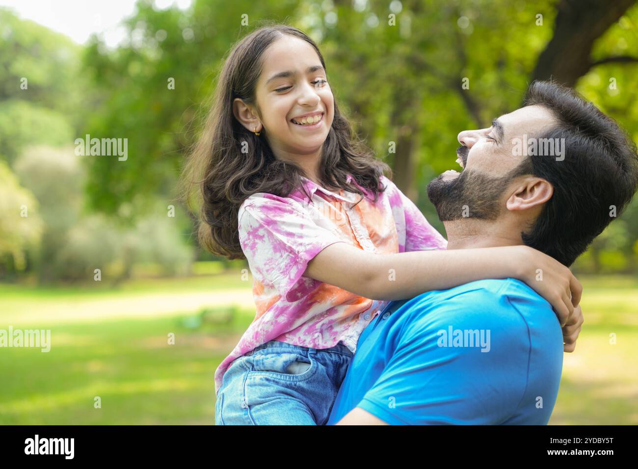 Jeune père indien joyeux portant la fille de maintien sur l'épaule amusez-vous ensemble au parc d'été. papa ludique et fille enfant. Liaison, amour et tog Banque D'Images