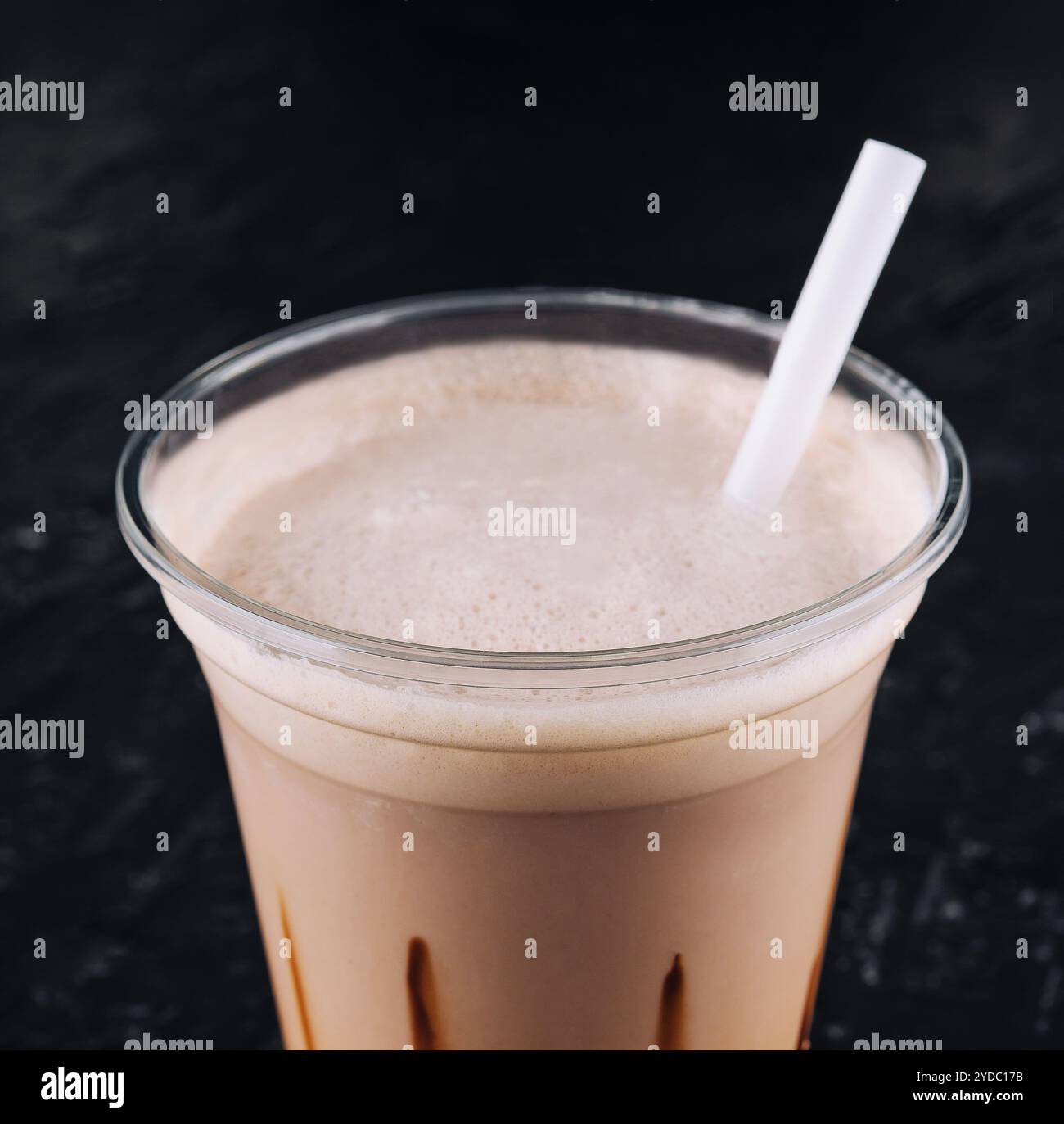 Milkshake dans une tasse en plastique sur fond noir Banque D'Images
