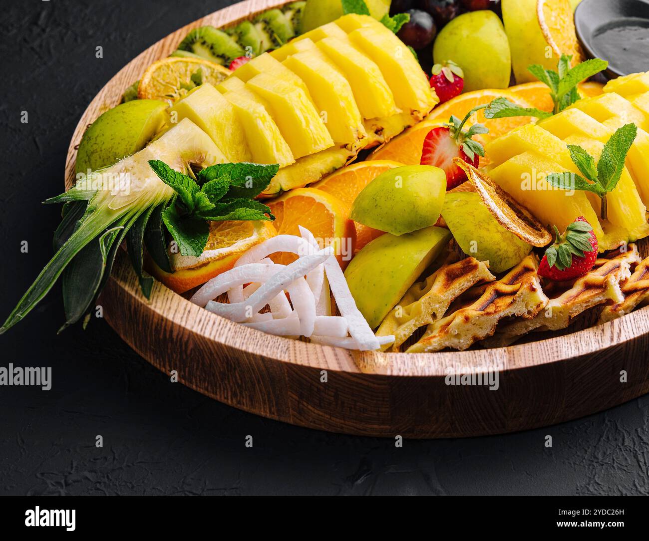 Une assiette de fruits assortis sur pierre noire Banque D'Images