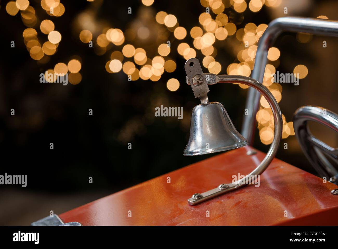 Vintage Silver Bell sur la surface rouge avec fond de lumières dorées floues. Banque D'Images