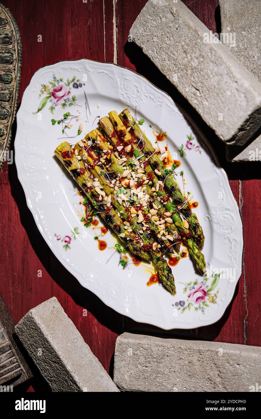 Asperges cuites au four avec des pignons de pin sur l'assiette Banque D'Images