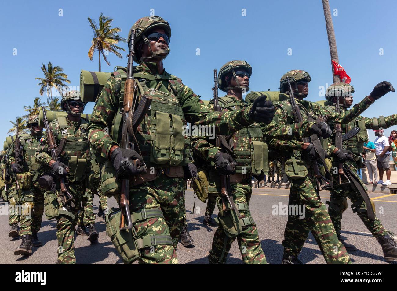 Soldats africains marchant avec des bedrolls et des armes de combat dans une rue de la ville Banque D'Images