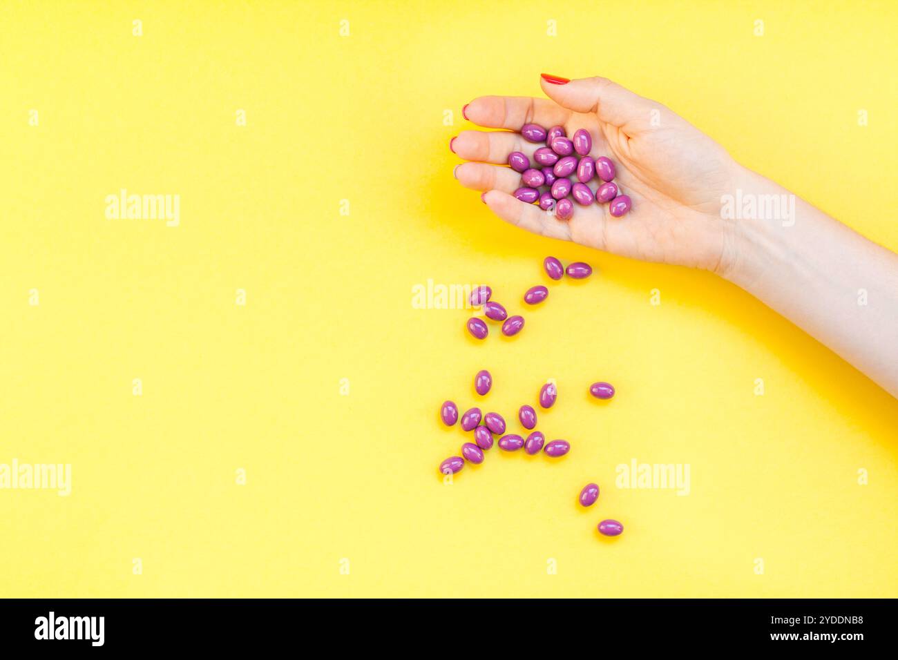 Main de femme tenant des pilules violettes poignée Banque D'Images