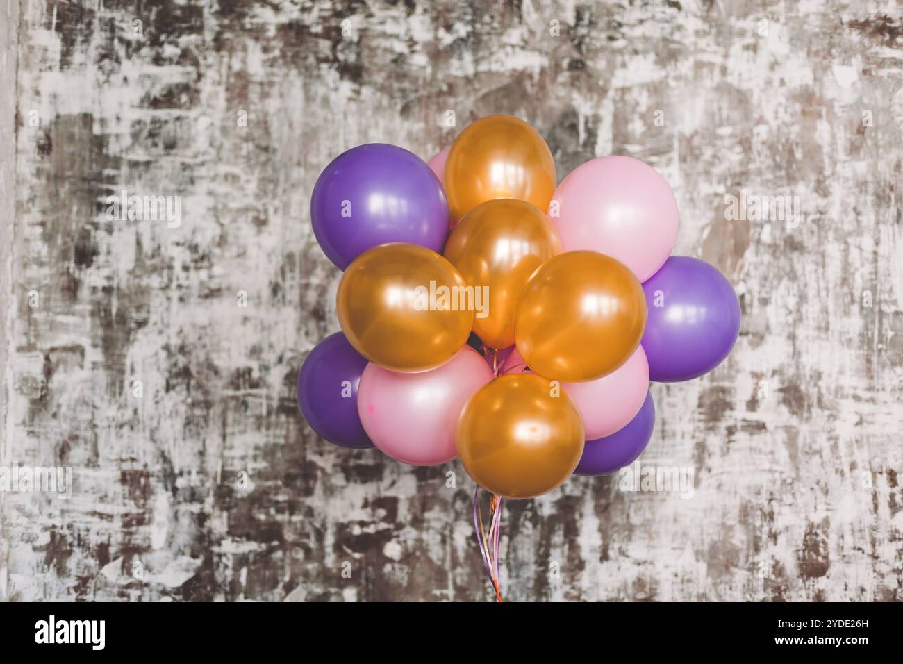Bouquet de ballons lumineux contre un mur texturé Banque D'Images