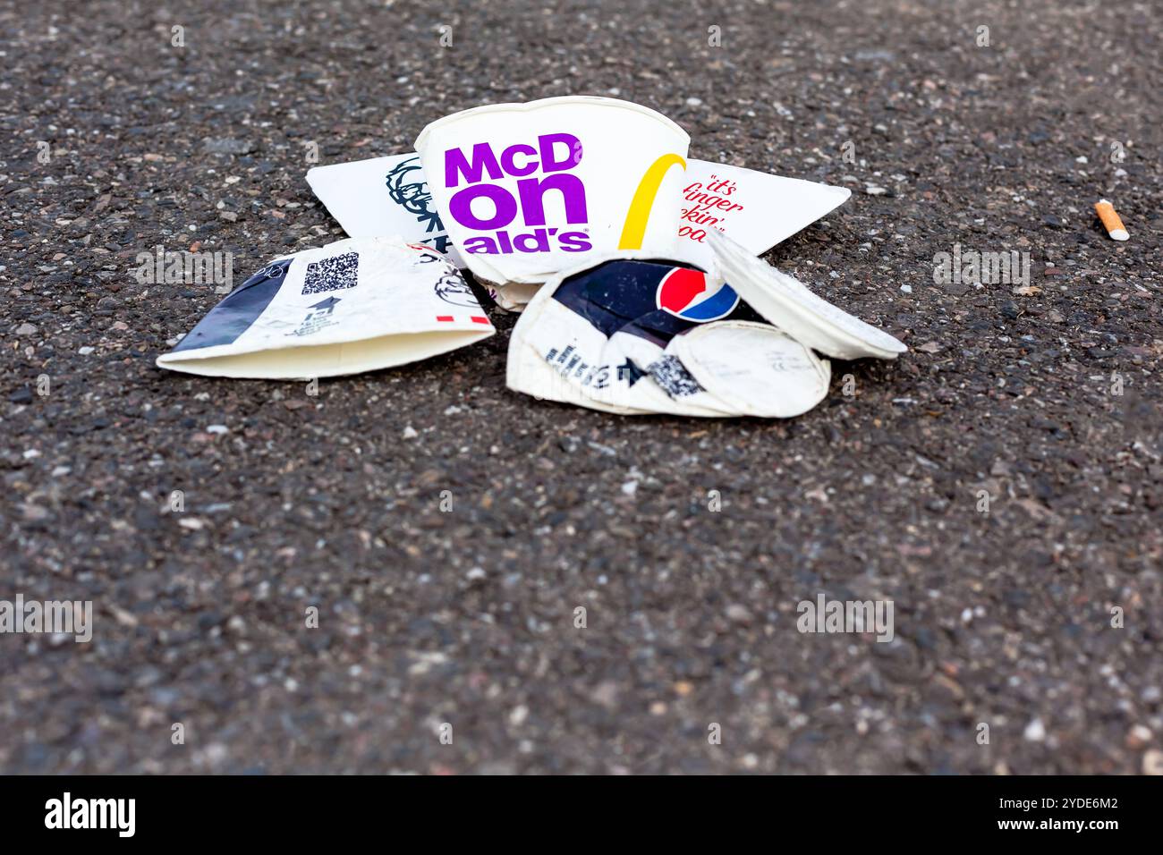 Déchets jetables de tasses de restauration rapide sur la route asphaltée Banque D'Images