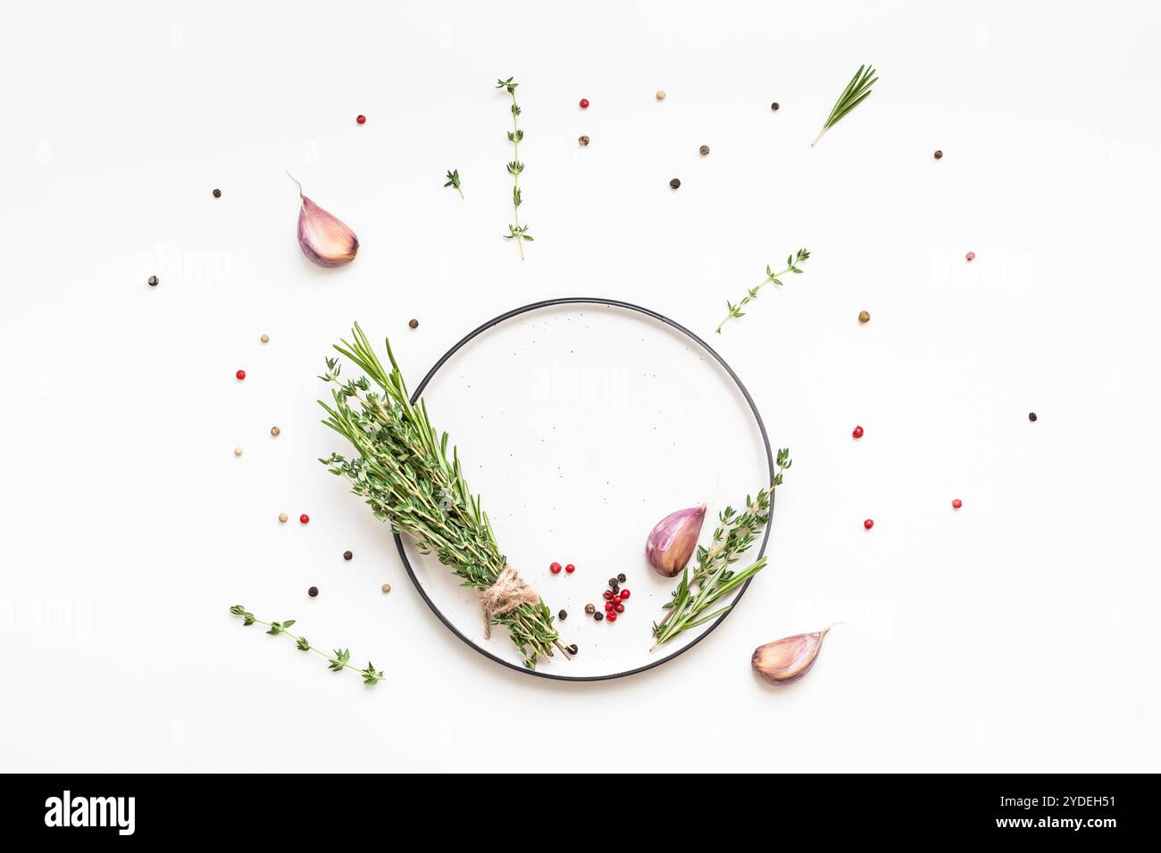 Assiette vide avec des herbes vertes et des épices autour Banque D'Images