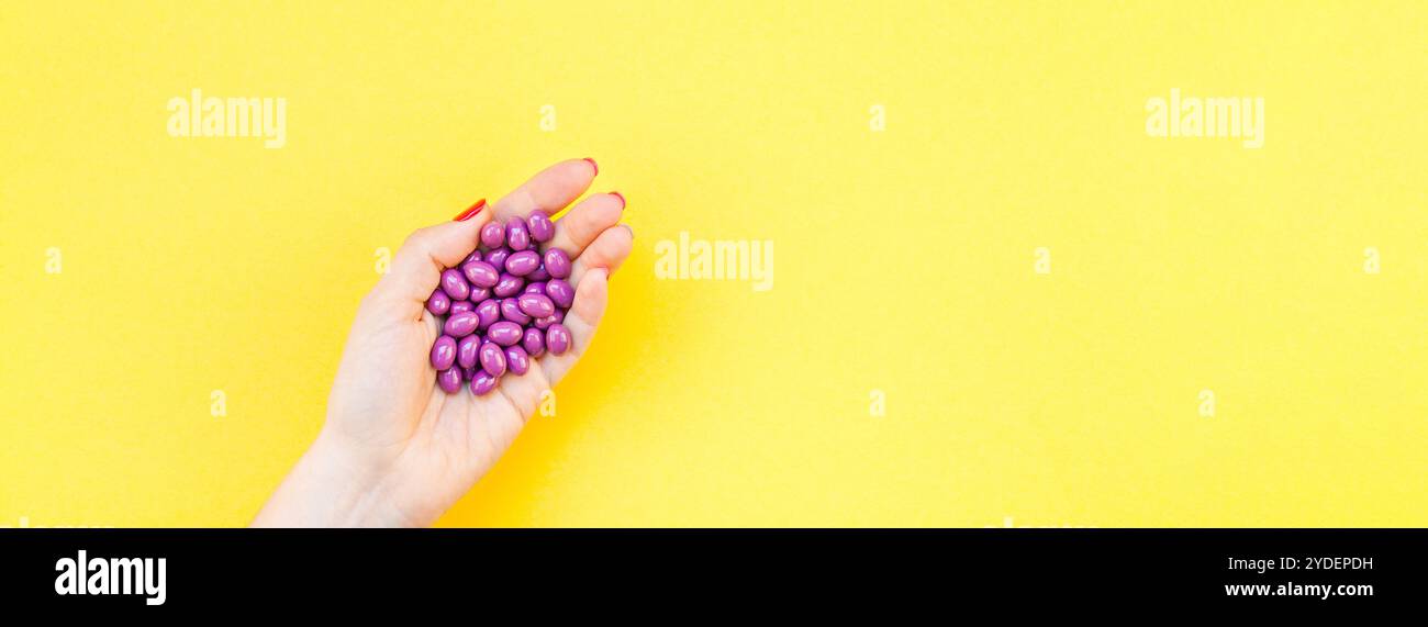 Main de femme tenant des pilules violettes poignée Banque D'Images
