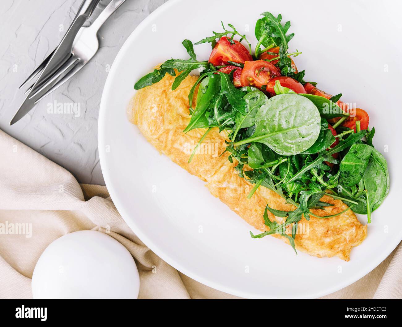 Omelette avec roquette, tomates et basilic dans une assiette Banque D'Images