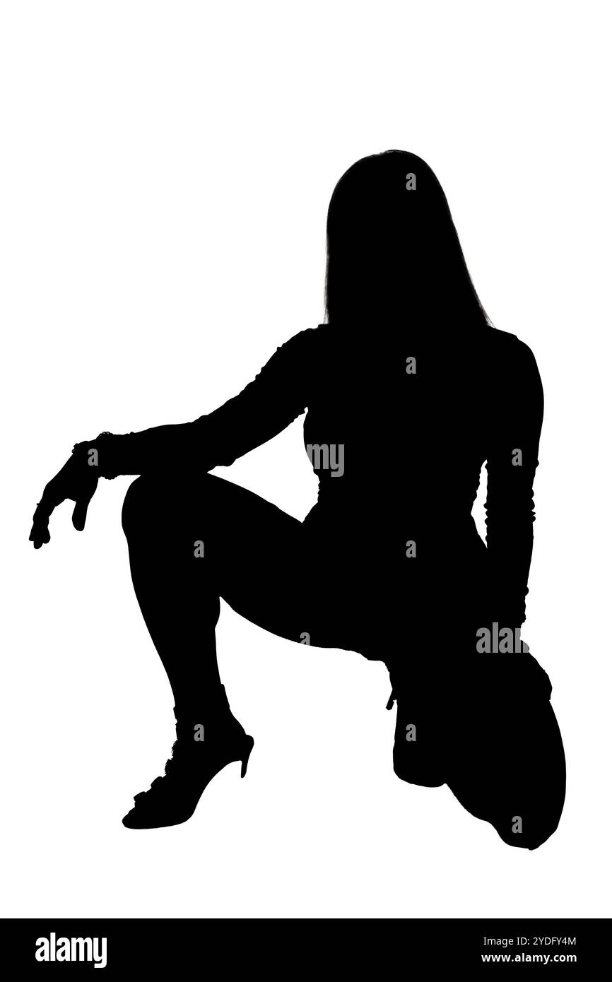 La silhouette élégante d'une femme tranquillement assise sur le sol avec ses jambes élégamment croisées sous elle, créant une image frappante Banque D'Images