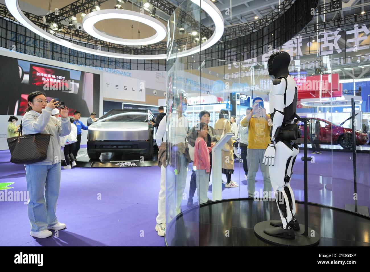 Weihai, province chinoise du Shandong. 26 octobre 2024. Les gens regardent un robot de Tesla lors d'une exposition de la célébration de la Journée mondiale des villes 2024 en Chine à Weihai, dans la province du Shandong de l'est de la Chine, Oct. 26, 2024. Plus de 2000 délégués de plus de 30 pays et régions ont assisté à l'événement. Crédit : Tang Ke/Xinhua/Alamy Live News Banque D'Images