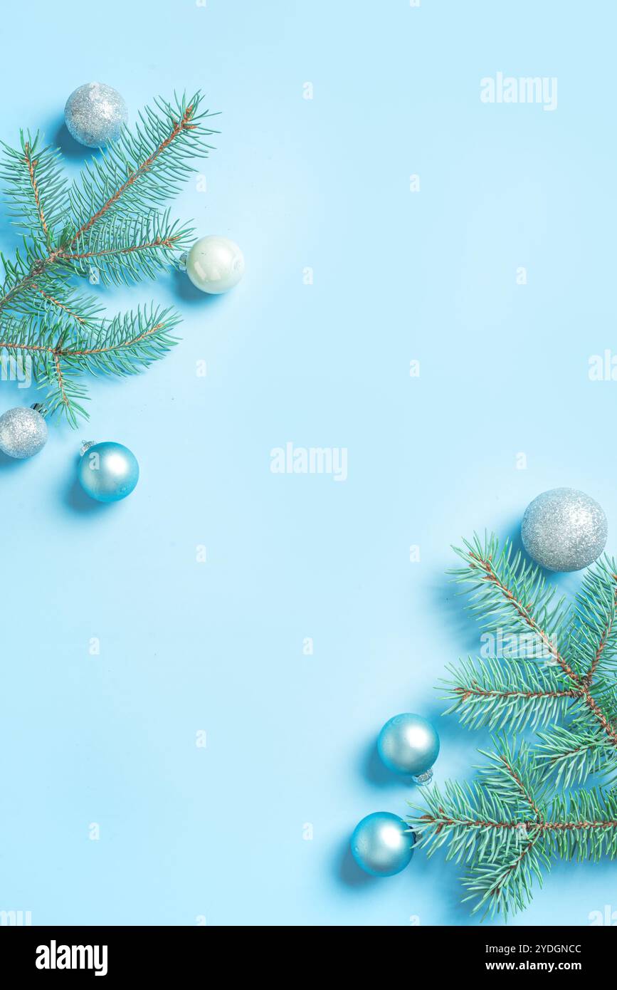 Composition de Noël bleue et argentée avec branches de sapin, boules sur fond bleu clair, papier peint mobile, espace de copie. Noël festif créatif de Banque D'Images