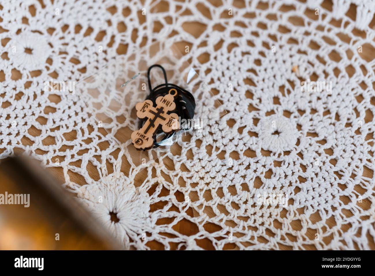 Pendentif en bois finement conçu sur une nappe de dentelle délicate. Banque D'Images