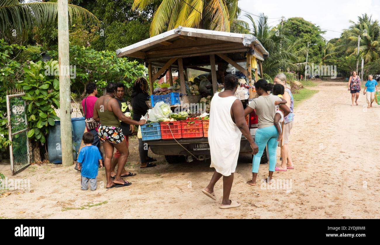 Les gens achètent de la nourriture dans un camion dans la rue à Hopkins, Belize Banque D'Images