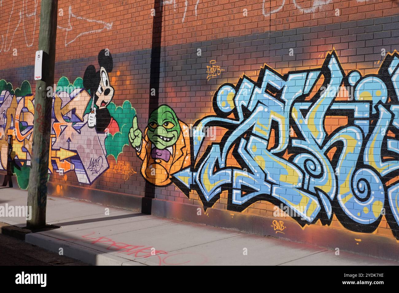 Graffiti de souris Micky sur un mur de briques rouges dans l'Industrial Inner West Sydenham, Sydney Banque D'Images
