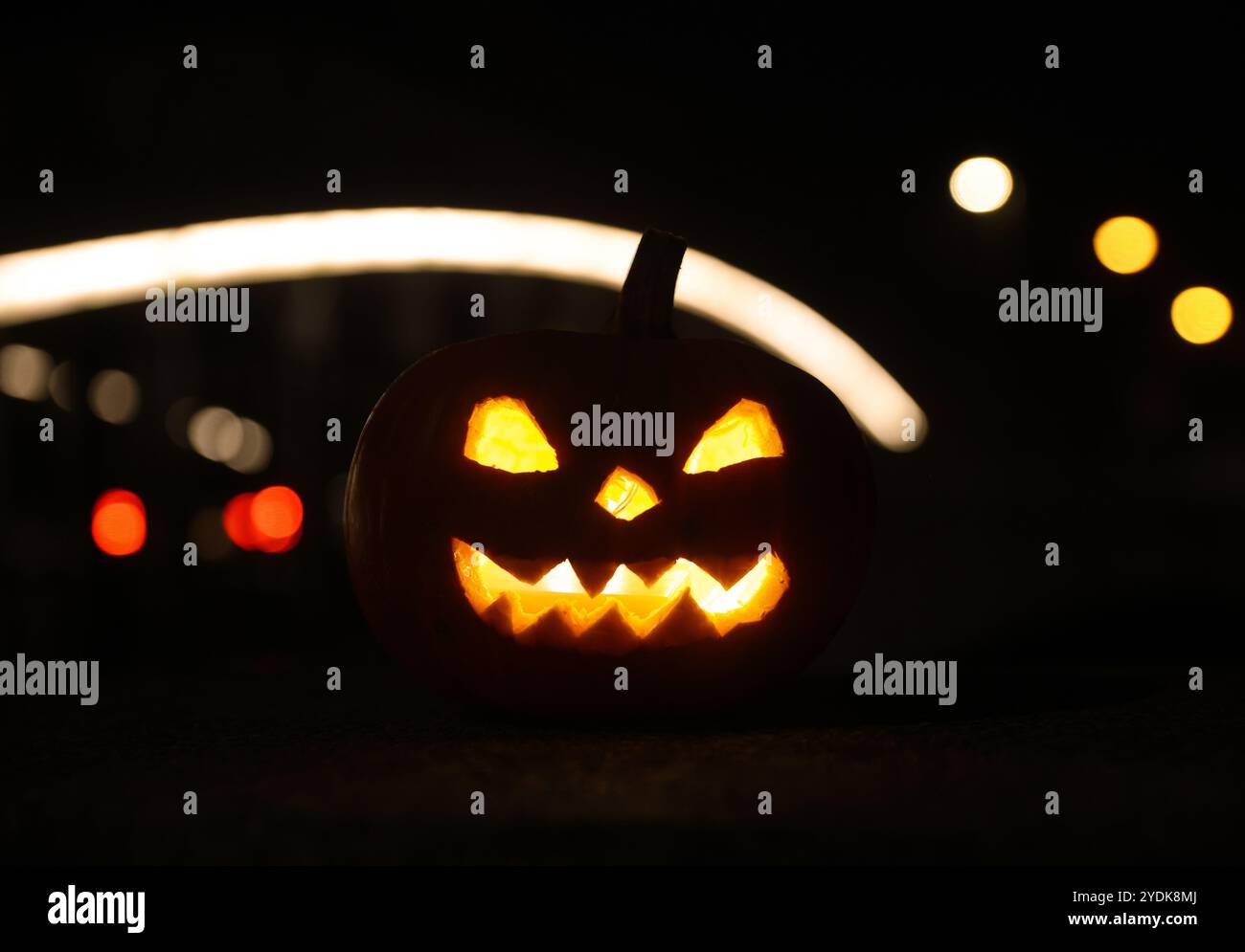 Riedlingen, Allemagne. 27 octobre 2024. Une citrouille illuminée et évidée décorée d'un visage se dresse près d'un pont illuminé le matin. Crédit : Thomas Warnack/dpa/Alamy Live News Banque D'Images