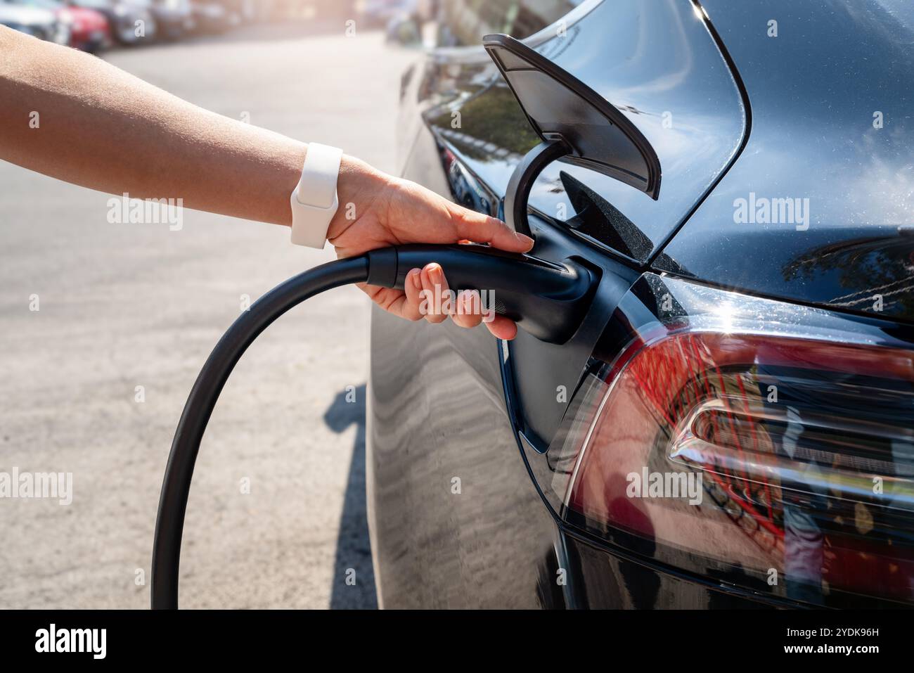 Gros plan connecteur de charge EV et voiture électrique. Conduite durable. Énergies renouvelables pour les transports. Banque D'Images