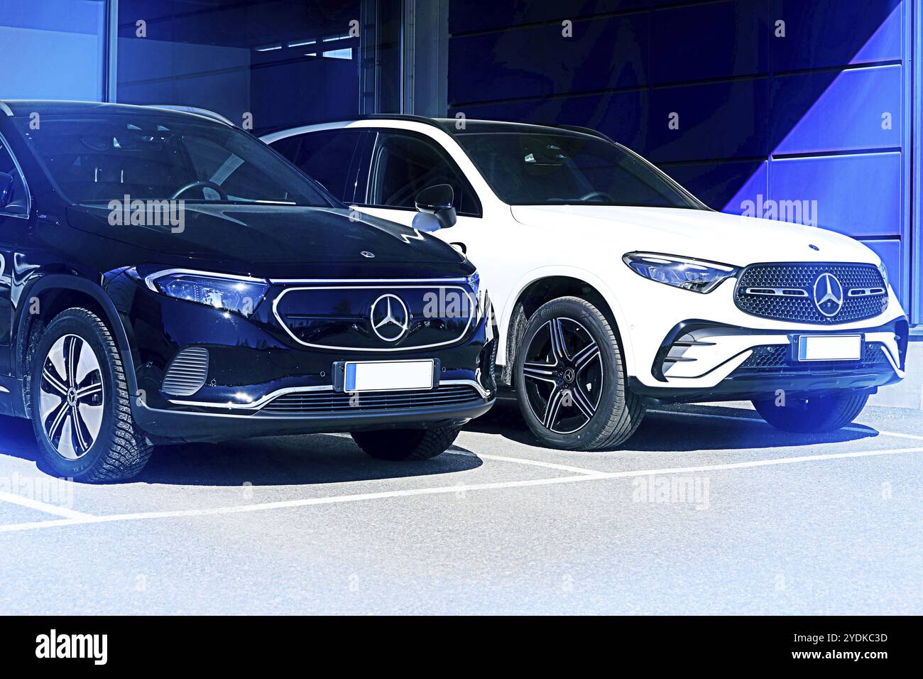 Noir Mercedes-Benz EQA 250 batterie SUV électrique année 2023 et nouveau blanc Mercedes-Benz 4matic SUV en lumière bleue. Salo, Finlande. 10 avril 2023 Banque D'Images