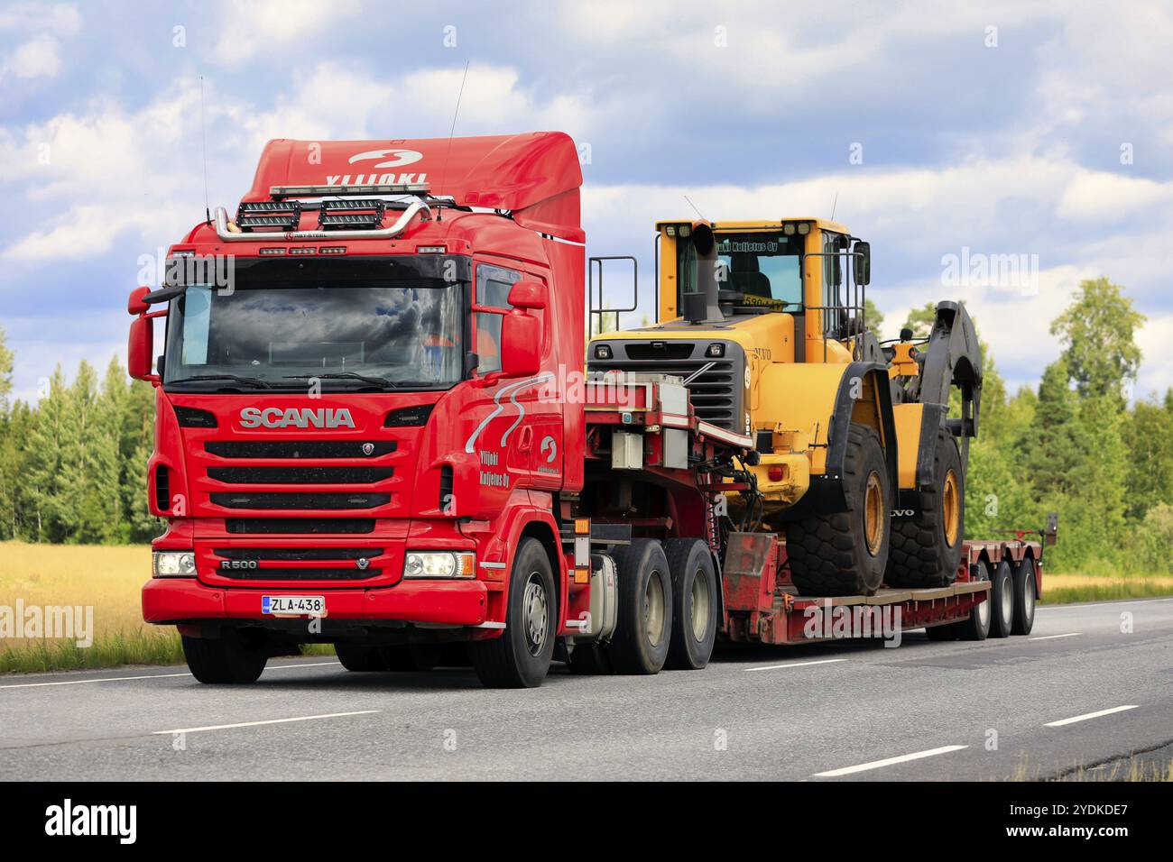 La semi-remorque Scania R500 Ylijoki Kuljetus Oy transporte une chargeuse sur pneus Volvo avec des grappins à grumes le long de l'autoroute. Jokioinen, Finlande. 7 août 2020 Banque D'Images